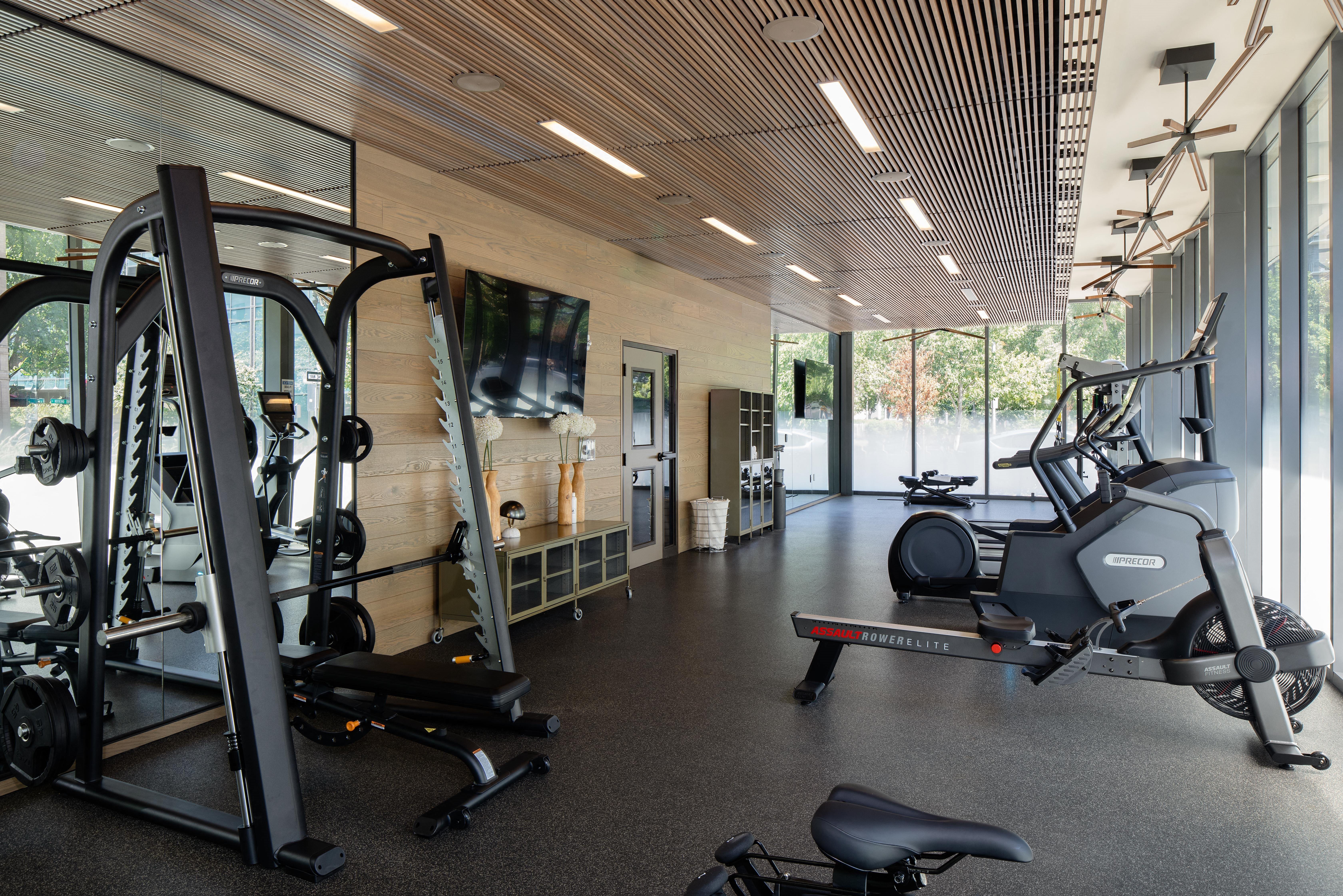 a gym with weights and a tv on the wall