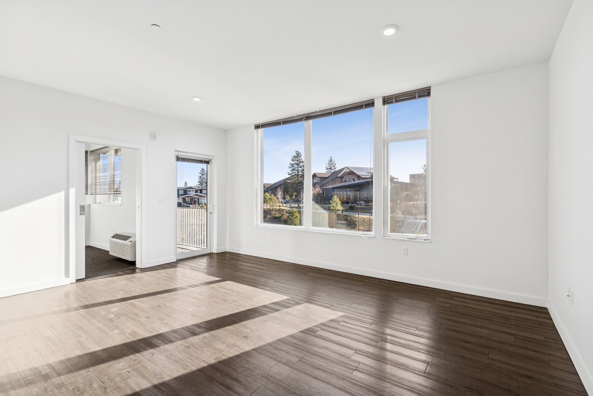 A large empty room with a view of the outside through the windows.