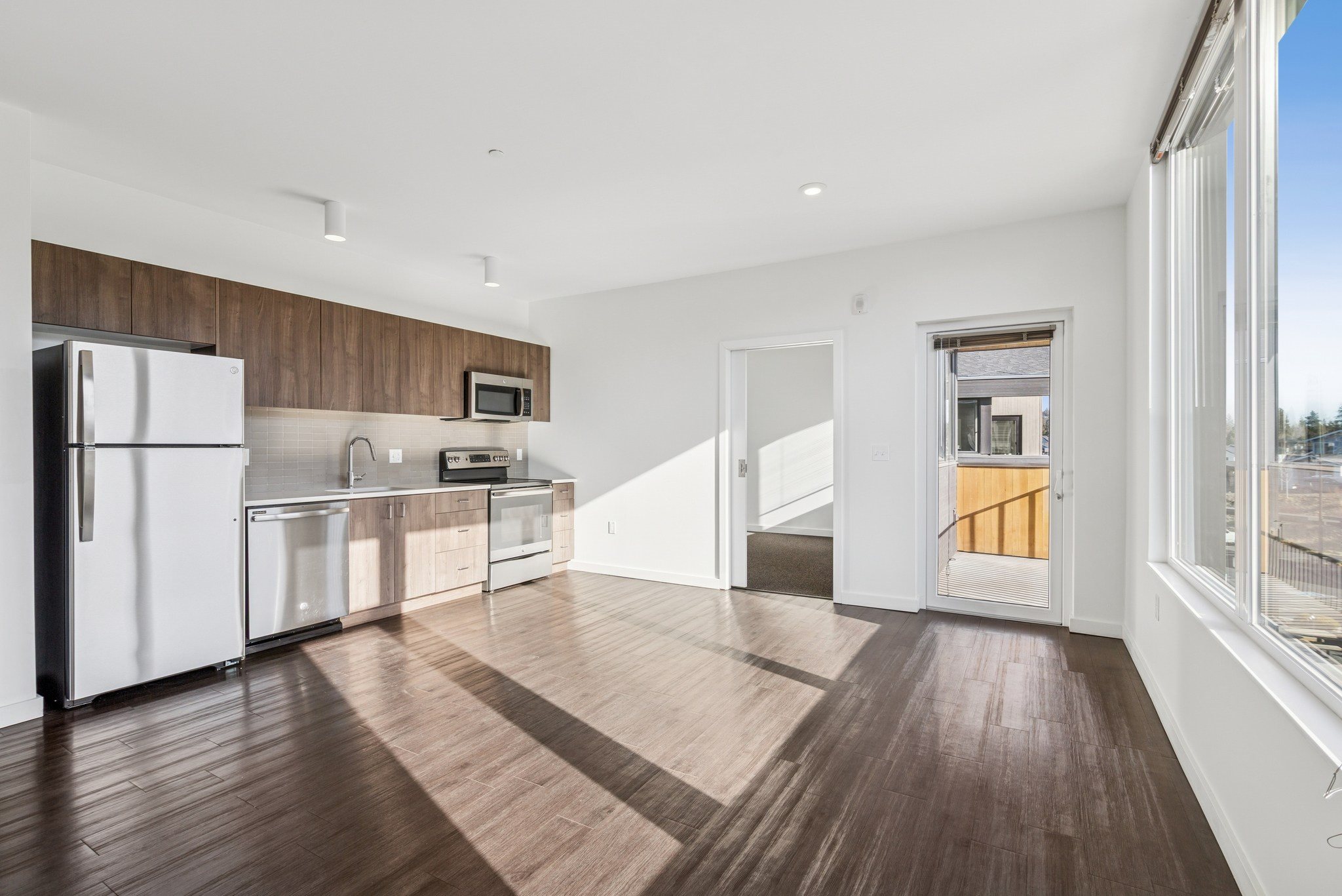 A kitchen with white appliances and wooden floors.,A kitchen with white appliances and wooden floors.