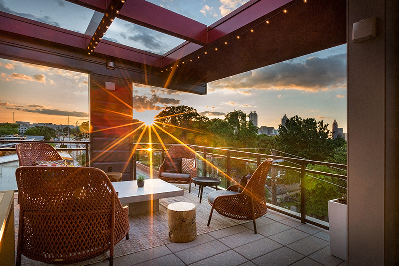 Outdoor rooftop terrace with seating areas during sunset.