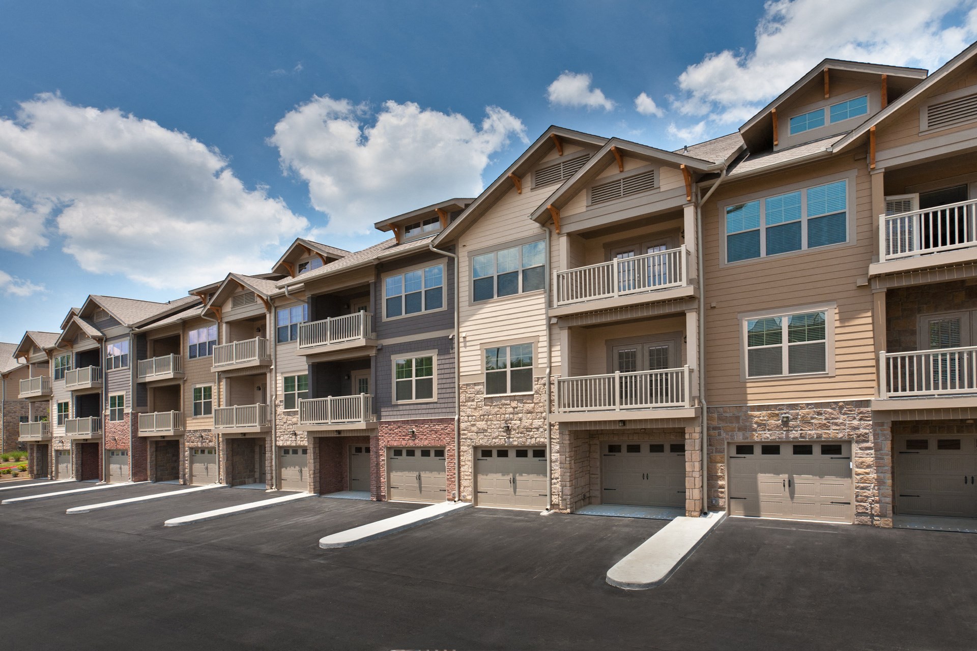 Exterior of The Regency townhomes with balconies and car garages attached.