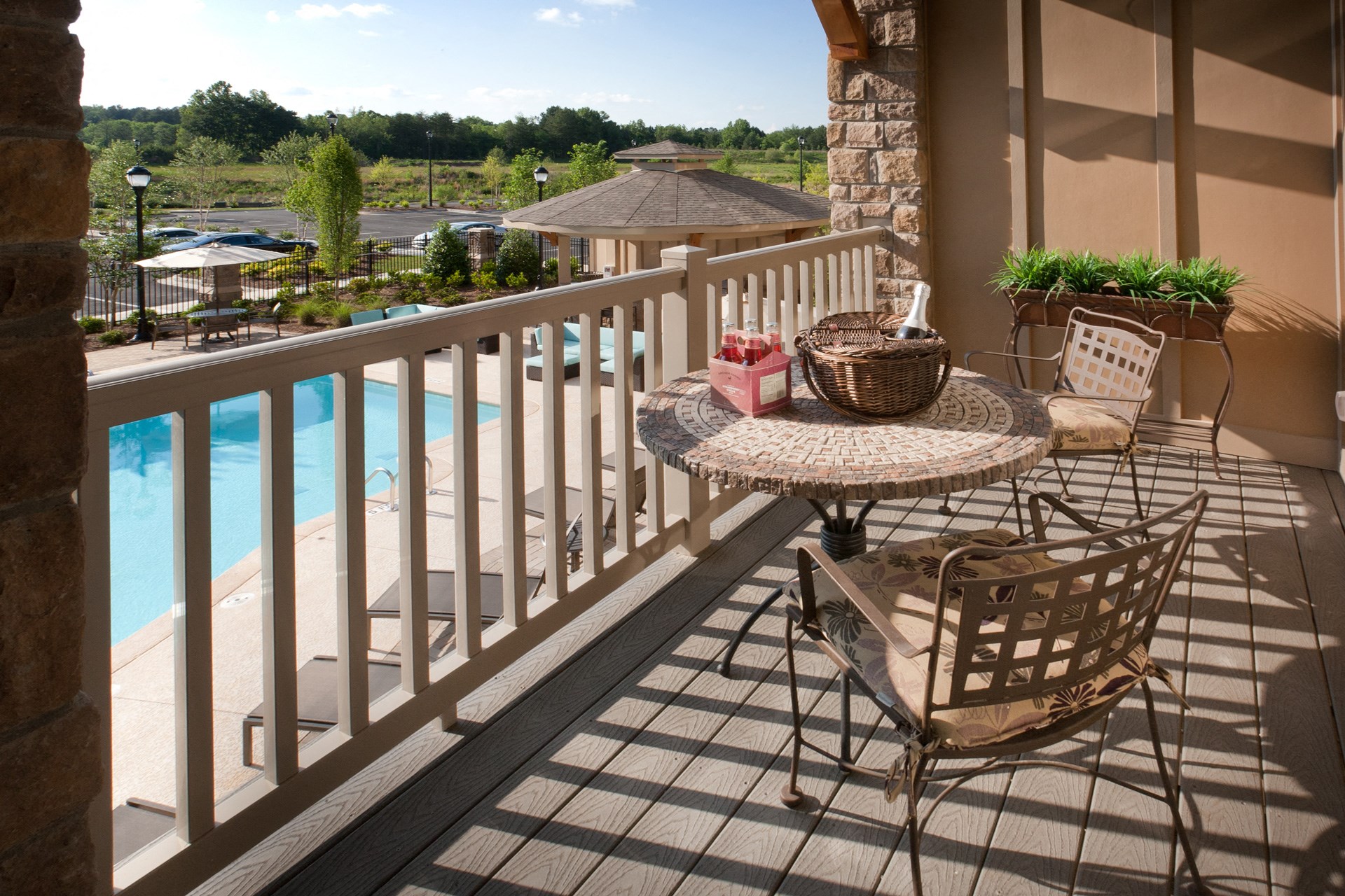 Balcony space with a table, two chairs, and a view of the pool area.