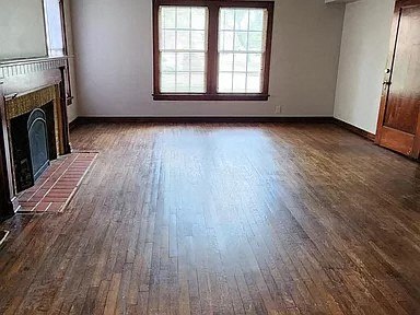 a living room with wood floors and a fireplace
