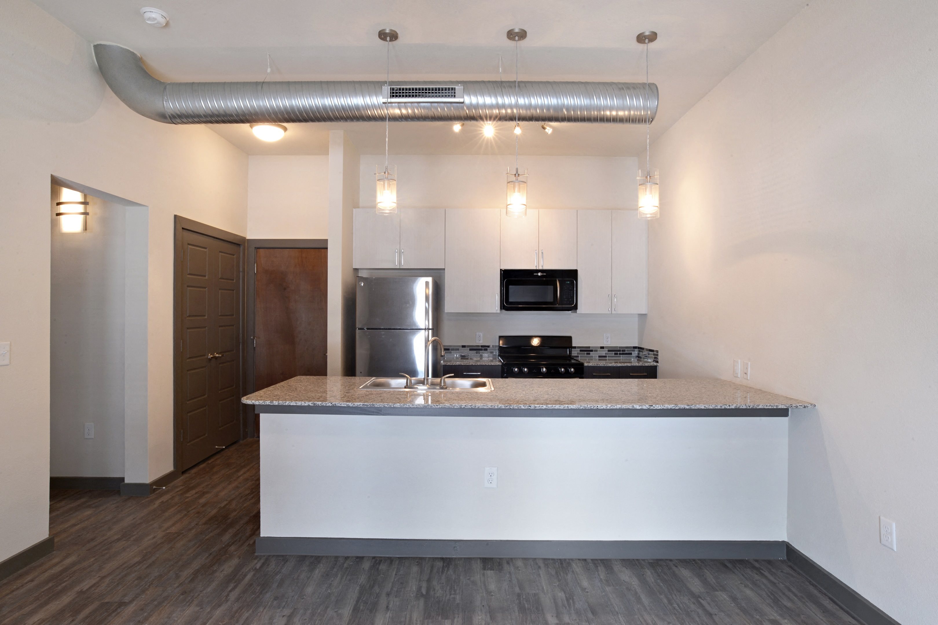 Kitchen with counter and cabinet at East End Lofts at the Railyard Apartments, Denton, TX, 76201