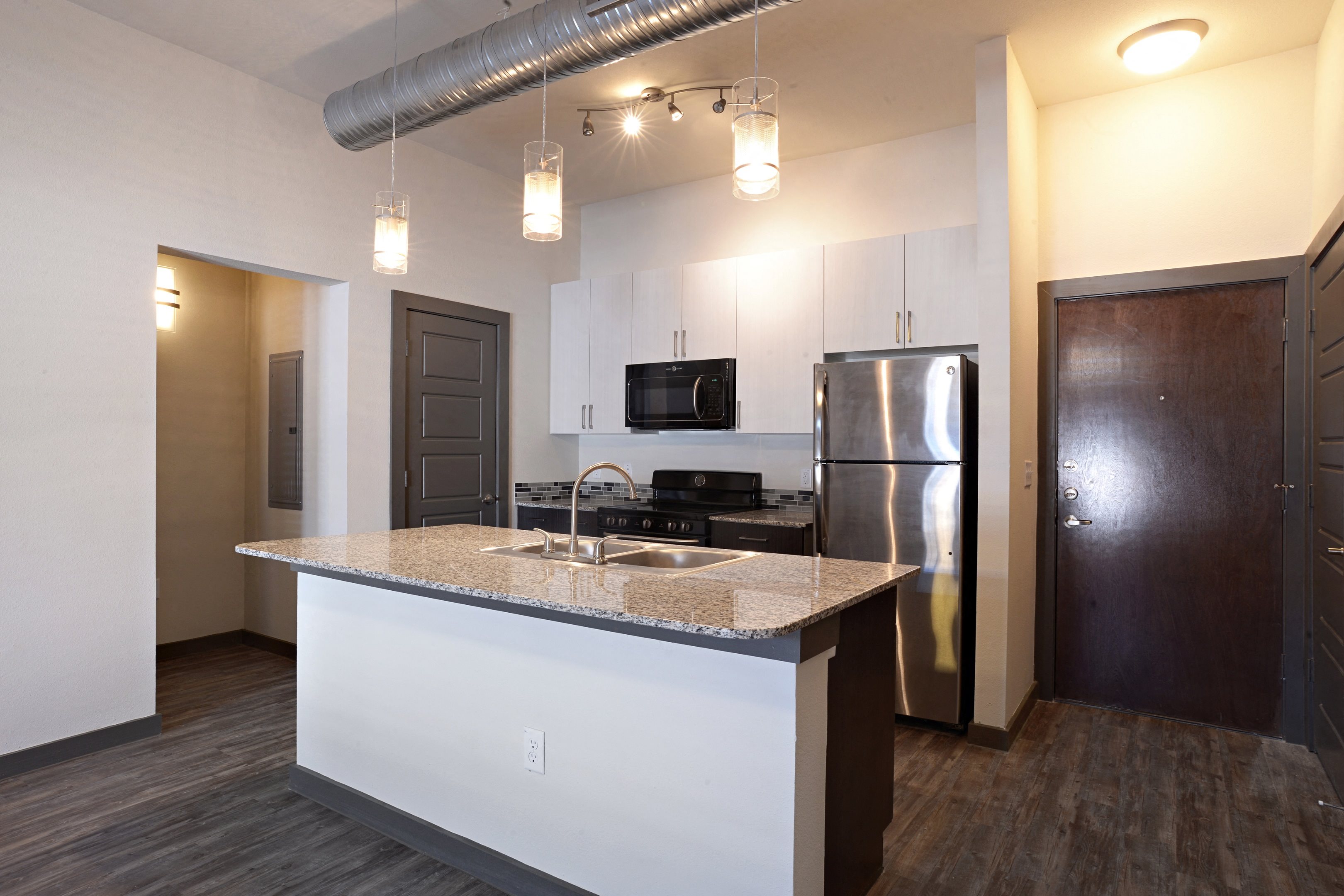 Kitchen with cabinets, lights at East End Lofts at the Railyard Apartments, Denton