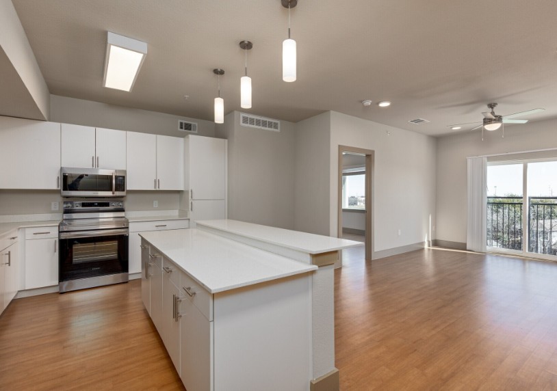 A spacious kitchen with white cabinets and a large island.