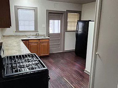 an empty kitchen with a stove and a refrigerator