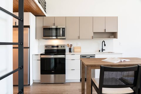 A modern kitchen with a black oven and white cabinets.