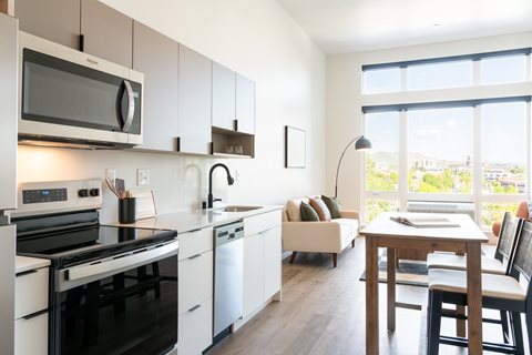 A modern kitchen with black appliances and white cabinets.