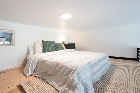 A bedroom with a large bed and a window.