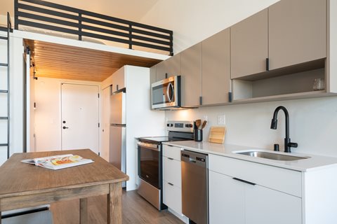A modern kitchen with a wooden table and white cabinets.