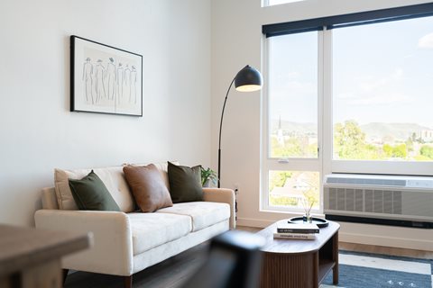 A living room with a couch, a table, a lamp, and a picture on the wall.