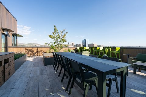 A long table with chairs is set up on a wooden deck.