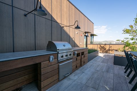 A modern outdoor kitchen with a grill and sink.