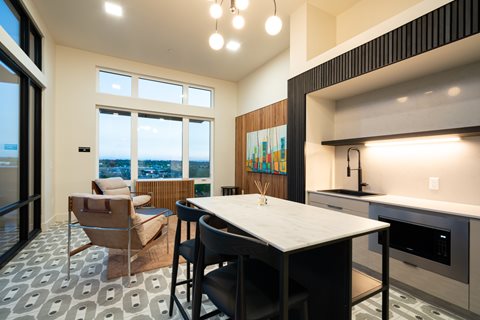 A modern kitchen with a table and chairs in front of a window.