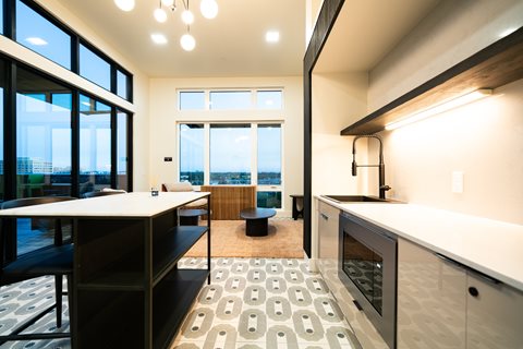 A modern kitchen with a large island and a view of the city.