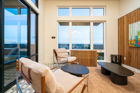 A room with a view of the city through large windows.