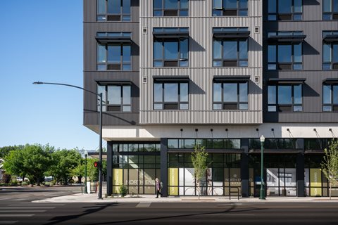 A modern building with a glass entrance and a street in front.