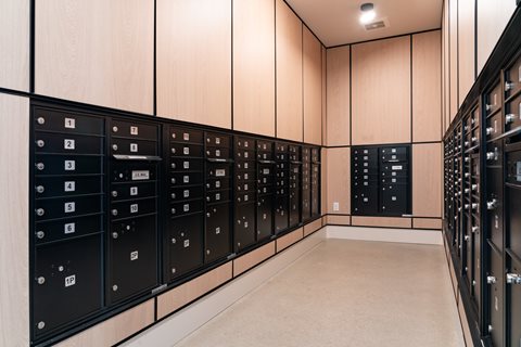A series of black mailboxes with numbers on them.