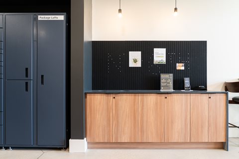 A black package lofts sign is on a black wall.