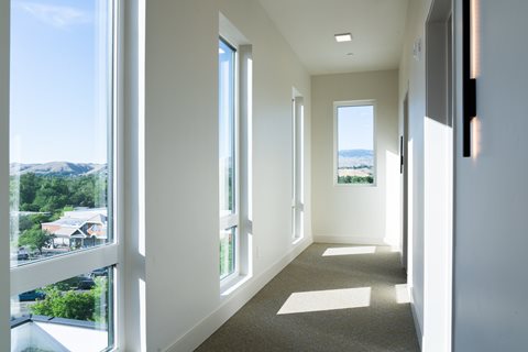 A long hallway with a view of the outdoors through the windows.