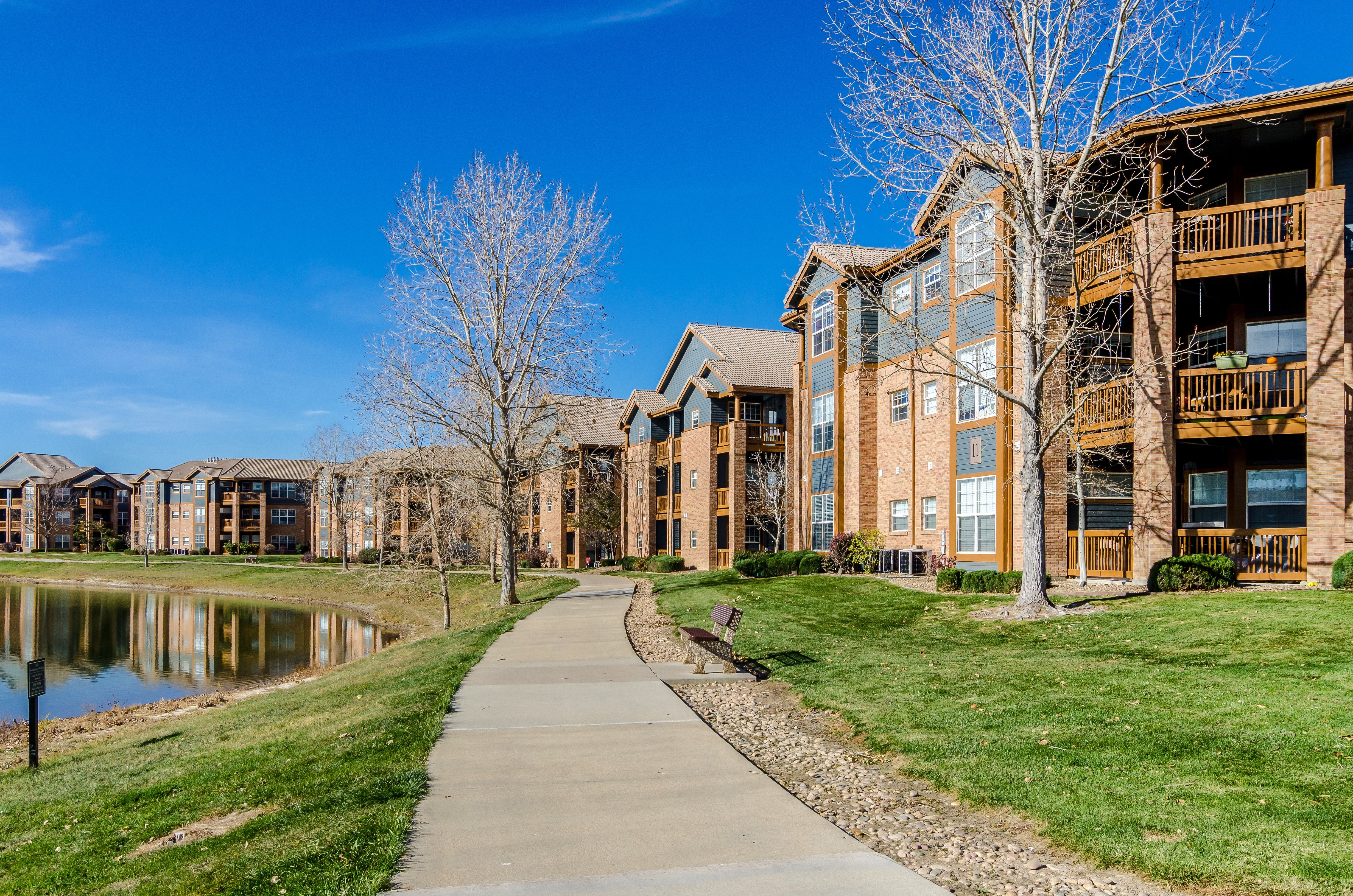 A row of buildings with a pond in front of them.