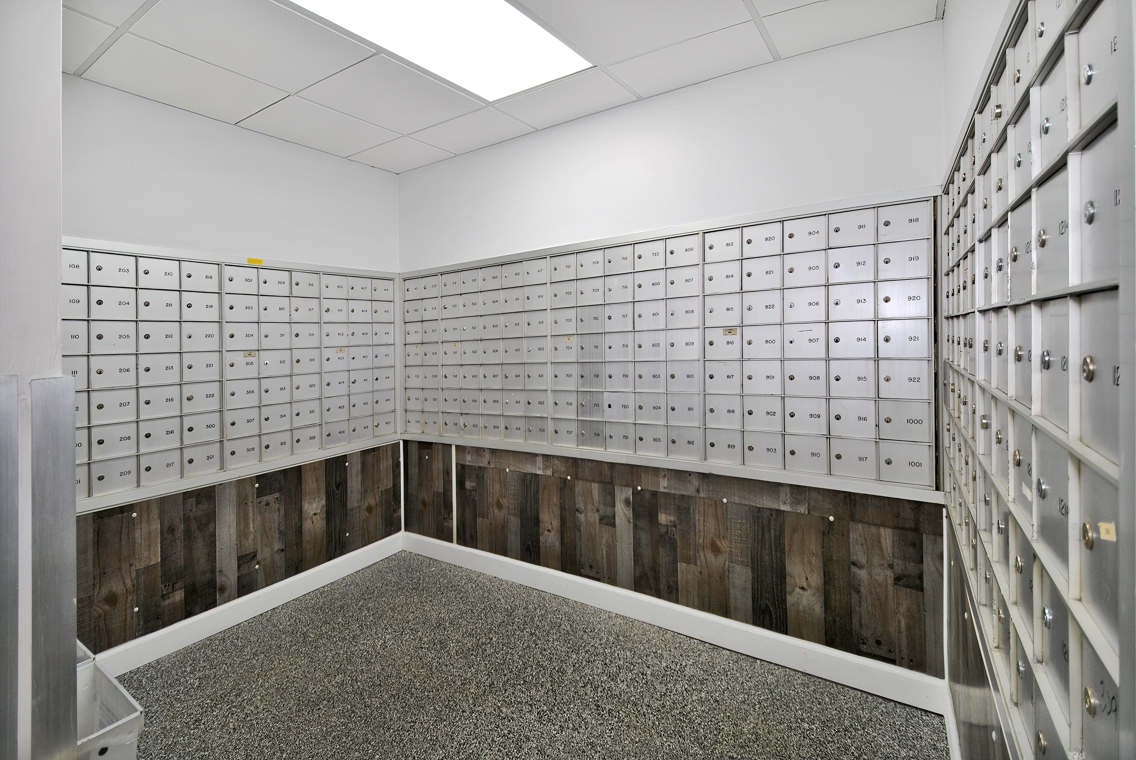 A room with a lot of mailboxes on the wall.