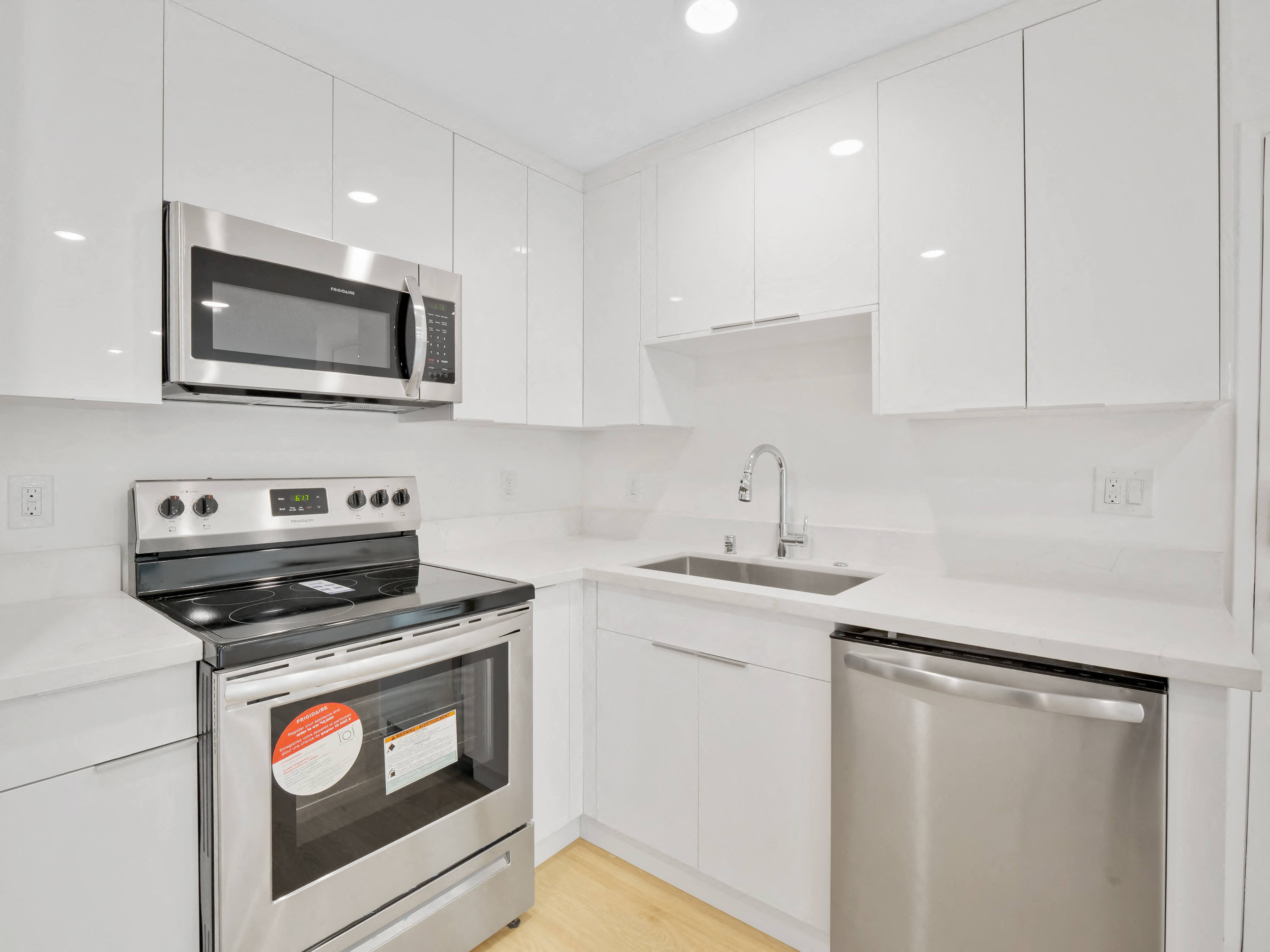 a kitchen with white cabinetry and stainless steel appliances