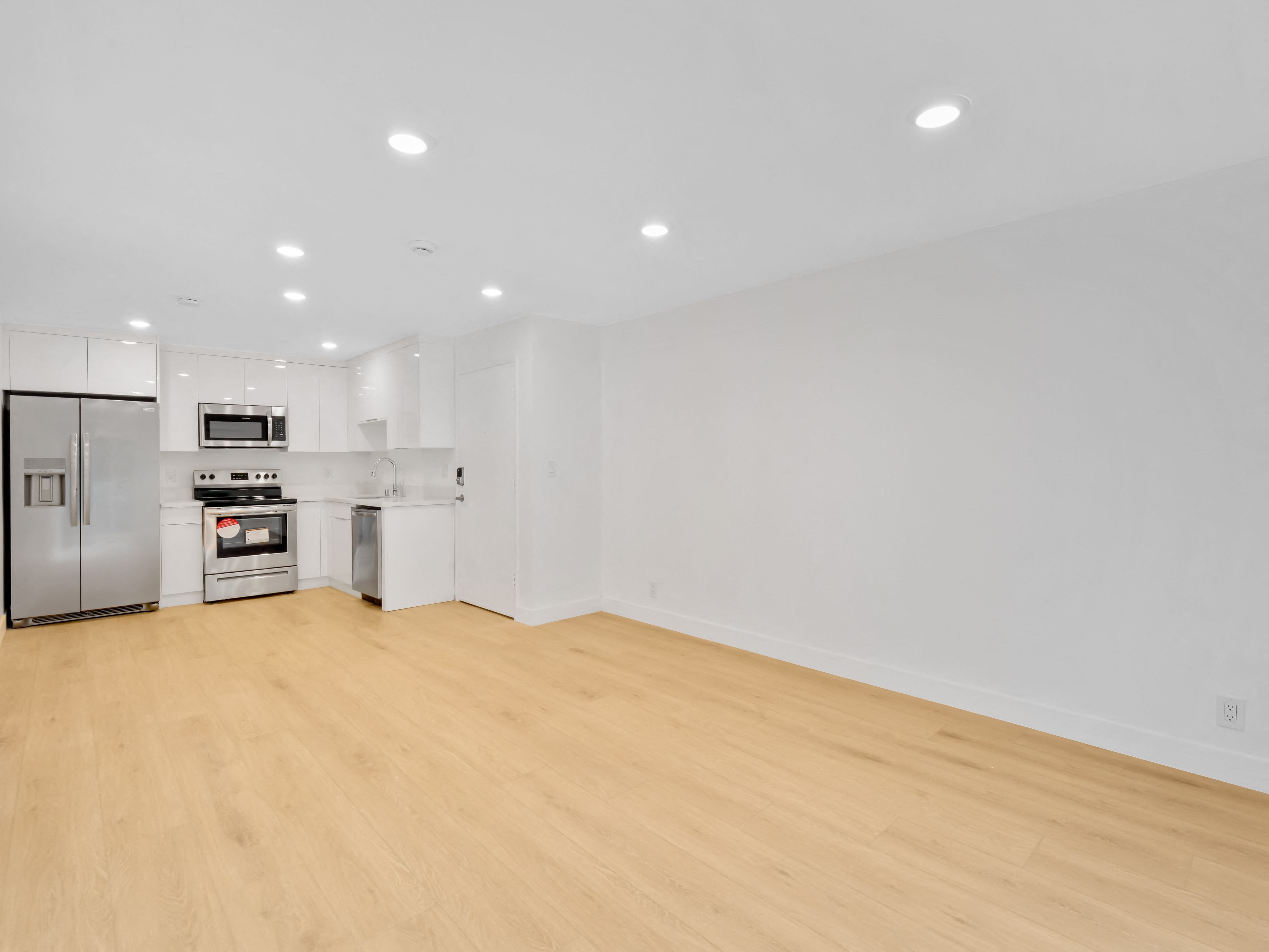 a living room with a hardwood floor and white walls