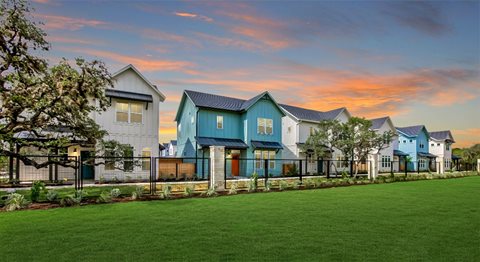 a row of houses in front of a green field