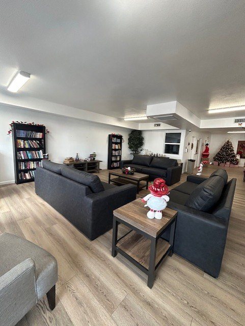 A room with a grey sofa, a black sofa, and a wooden coffee table