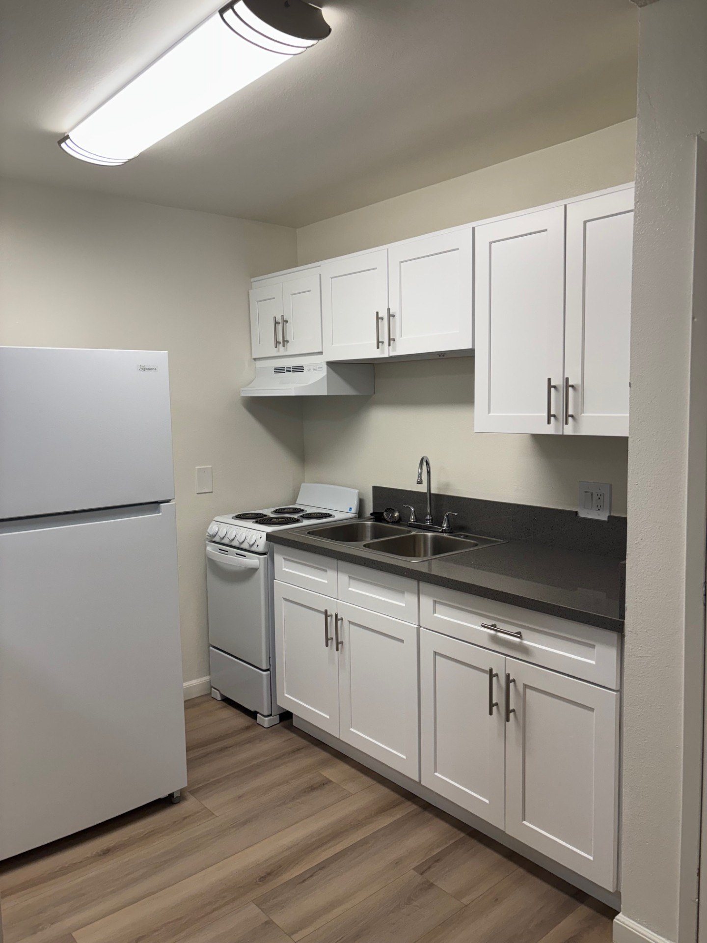 A kitchen with white appliances and cabinets.