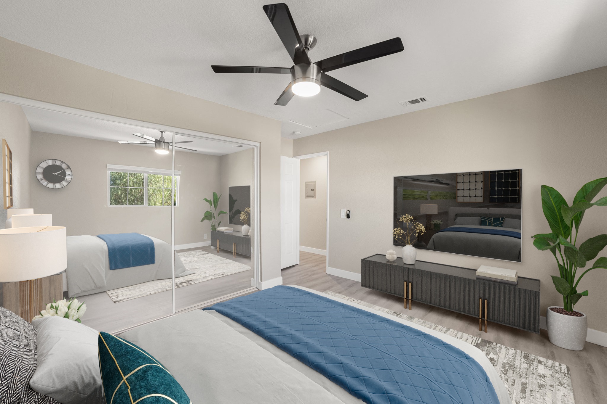 A bedroom with a bed, a ceiling fan, and a television.