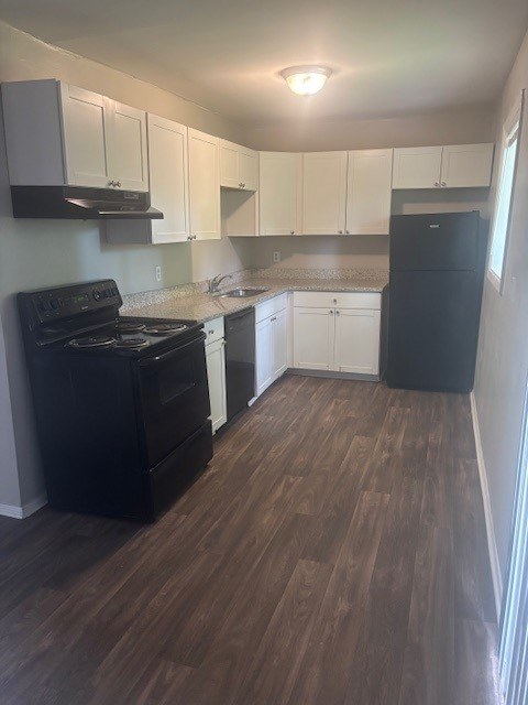 A kitchen with black appliances and white cabinets.,A kitchen with black appliances and white cabinets.