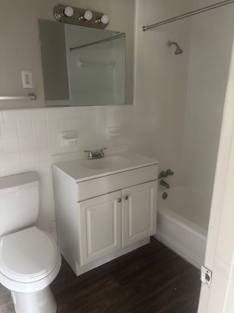 A white toilet sits next to a sink in a small bathroom.,A white toilet sits next to a sink in a small bathroom.