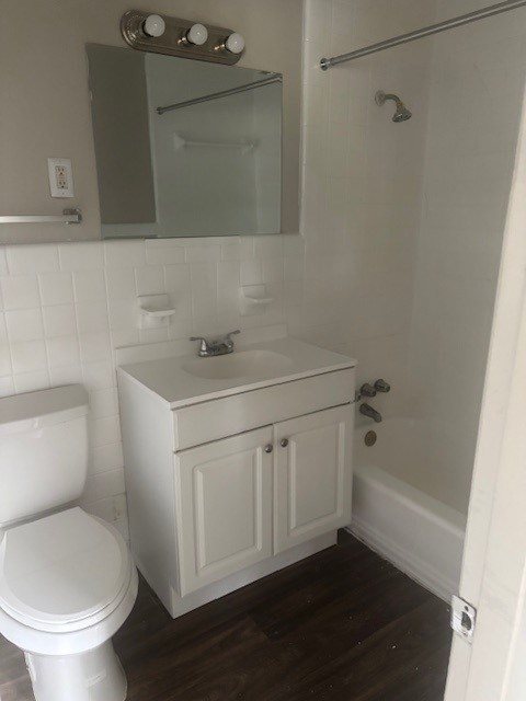 A white toilet sits next to a sink in a small bathroom.