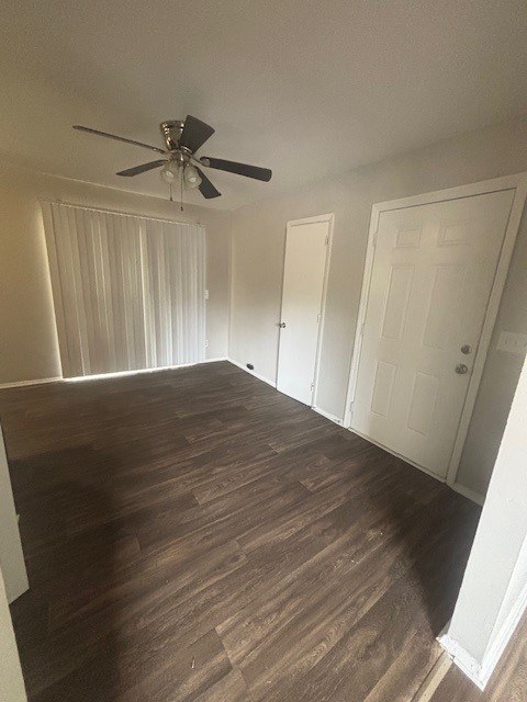A room with a ceiling fan and wooden flooring.,A room with a ceiling fan and wooden flooring.