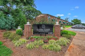 A sign that says Cobble Creek in front of a building.,A sign that says Cobble Creek in front of a building.