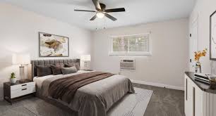 A bedroom with a bed, nightstand, and a ceiling fan.,A bedroom with a bed, nightstand, and a ceiling fan.