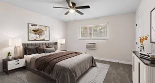 A bedroom with a bed, nightstand, and a ceiling fan.