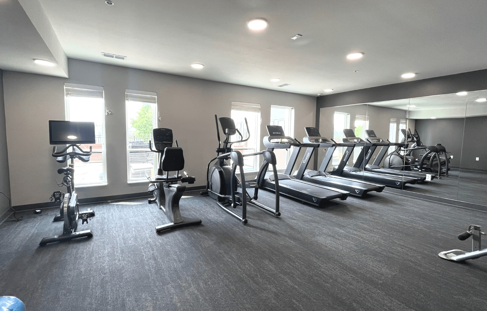a large fitness room with treadmills and ellipticals