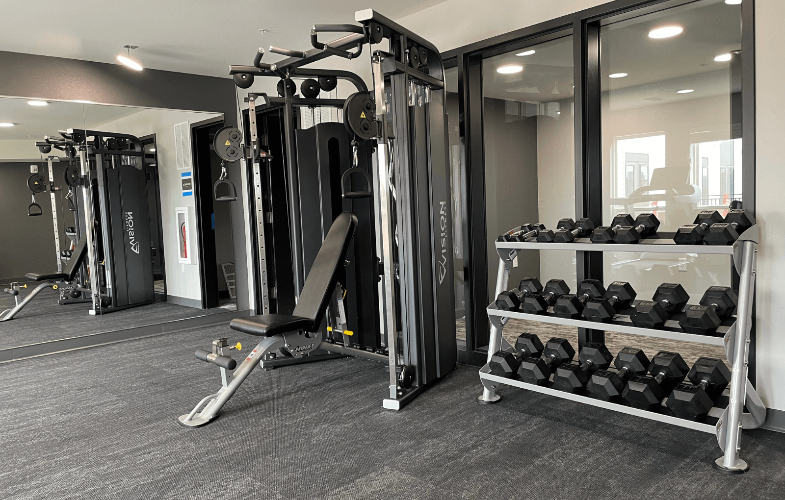 a fully equipped fitness room with weights and cardio equipment