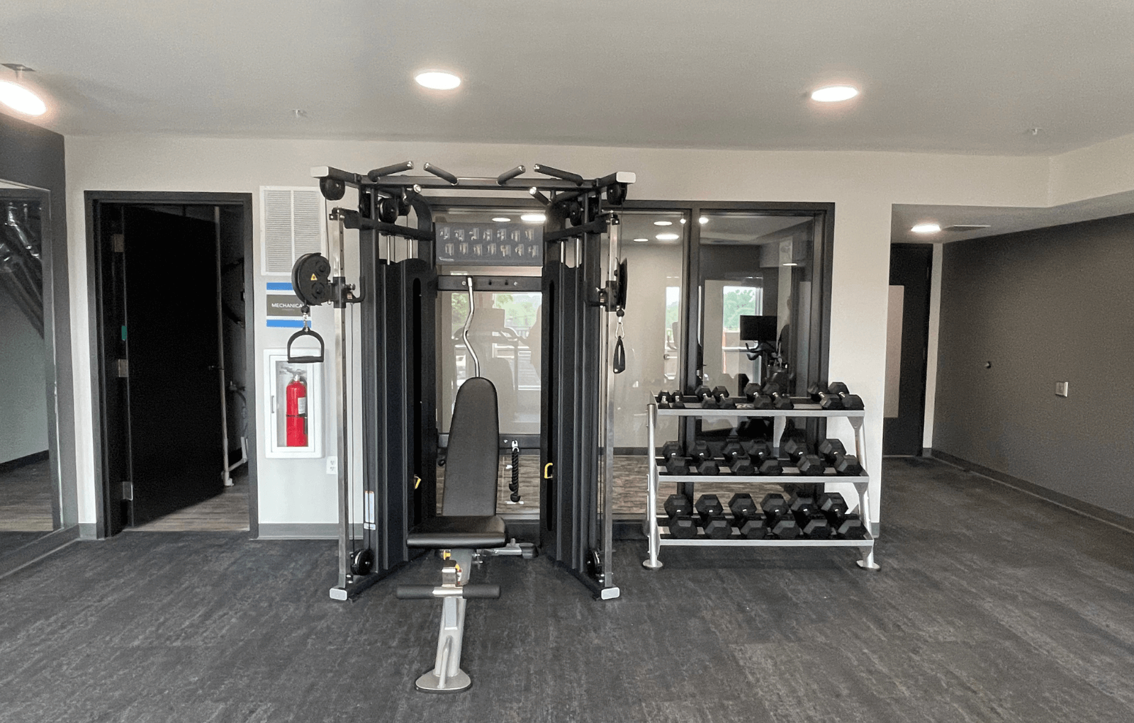 a home gym with a treadmill and weights rack