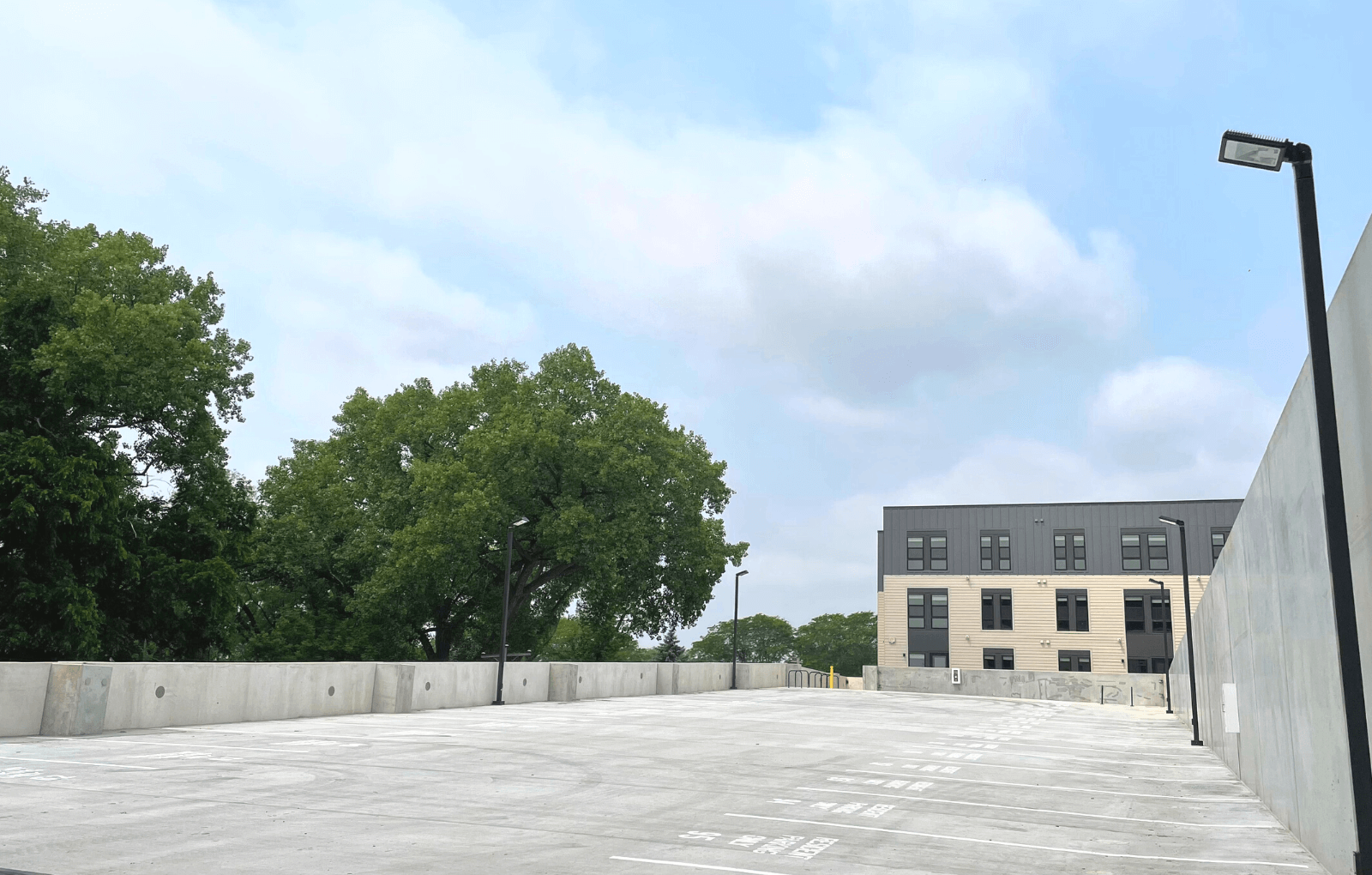 a large empty parking lot with a building in the background
