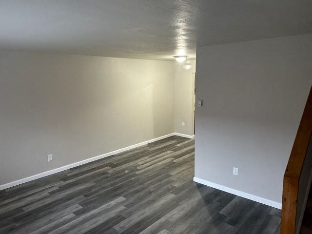 a empty room with wood floors and a white wall