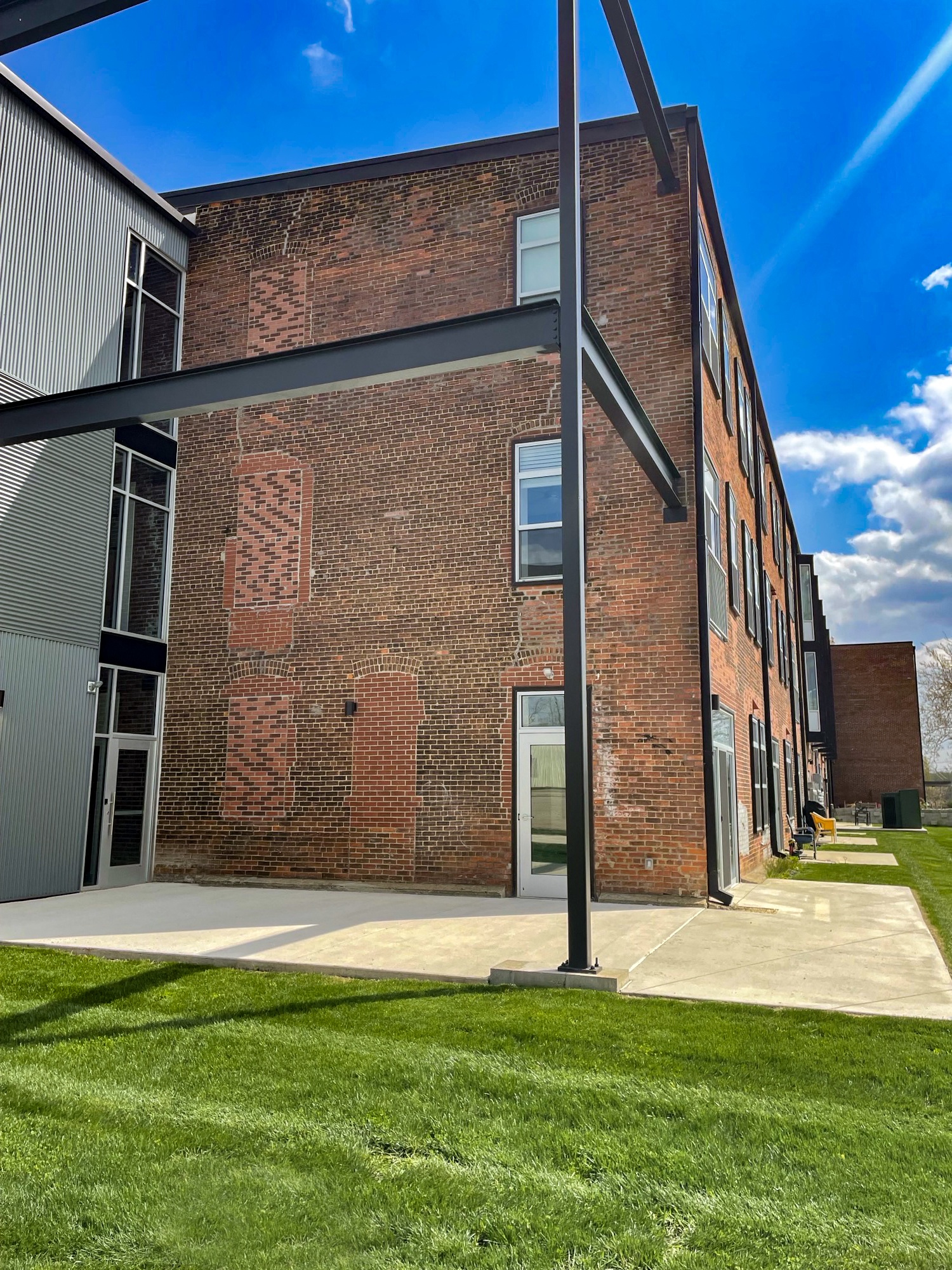 a large brick building with a grassy area in front of it