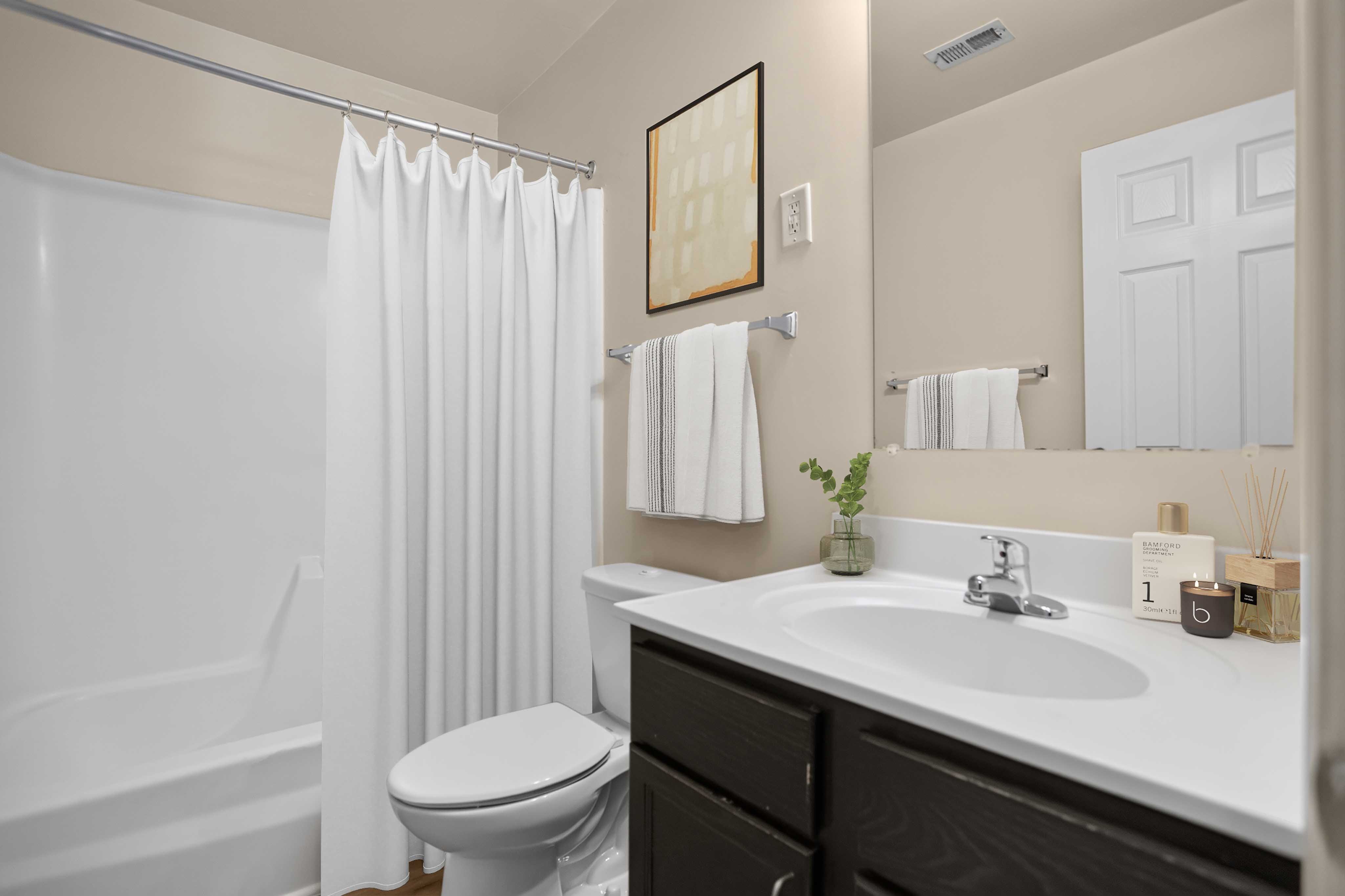 A bathroom with a white toilet, a white sink, and a white bathtub.
