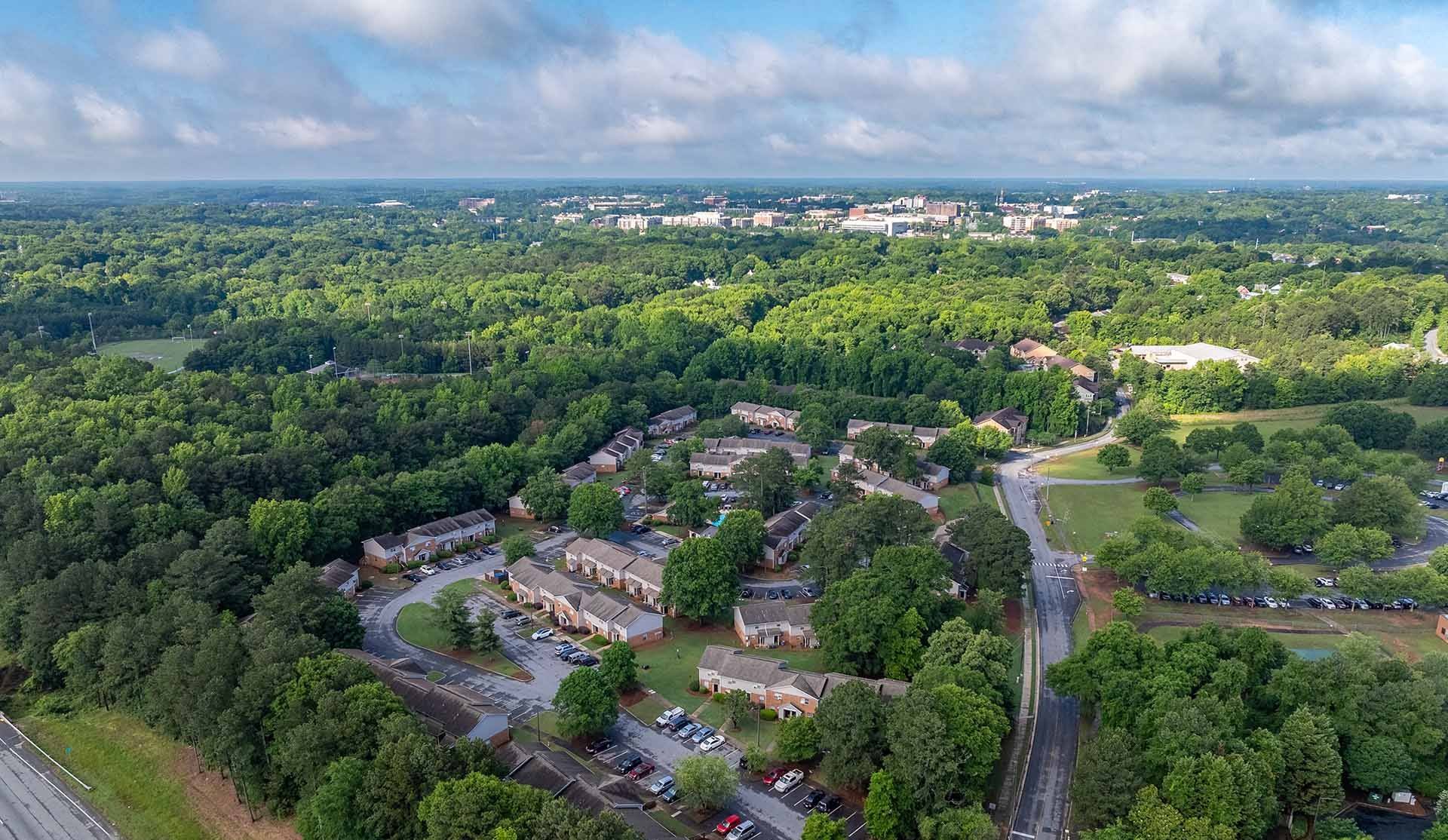 A bird's eye view of a small town with a mix of greenery and buildings.