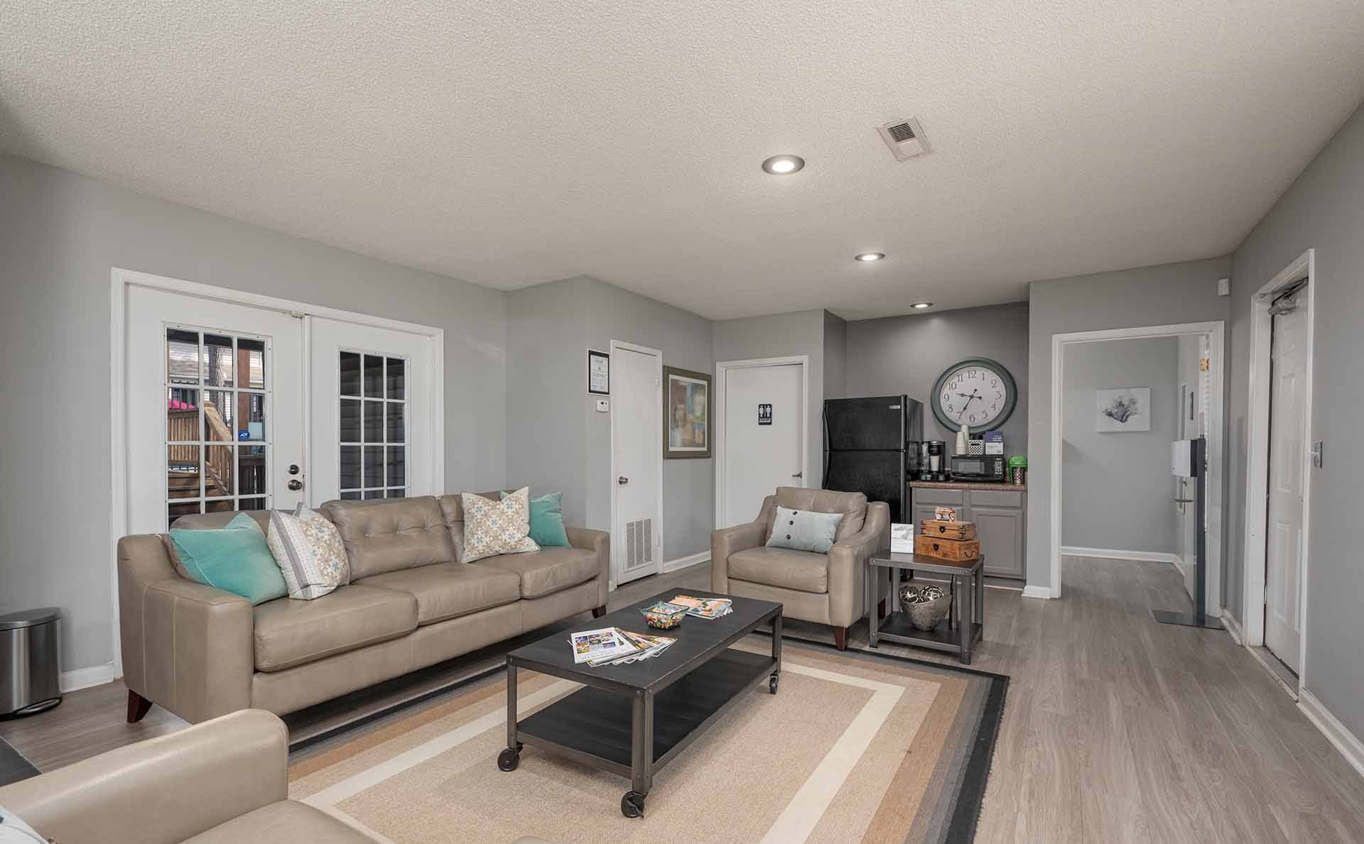 A living room with a couch, coffee table, and a rug.