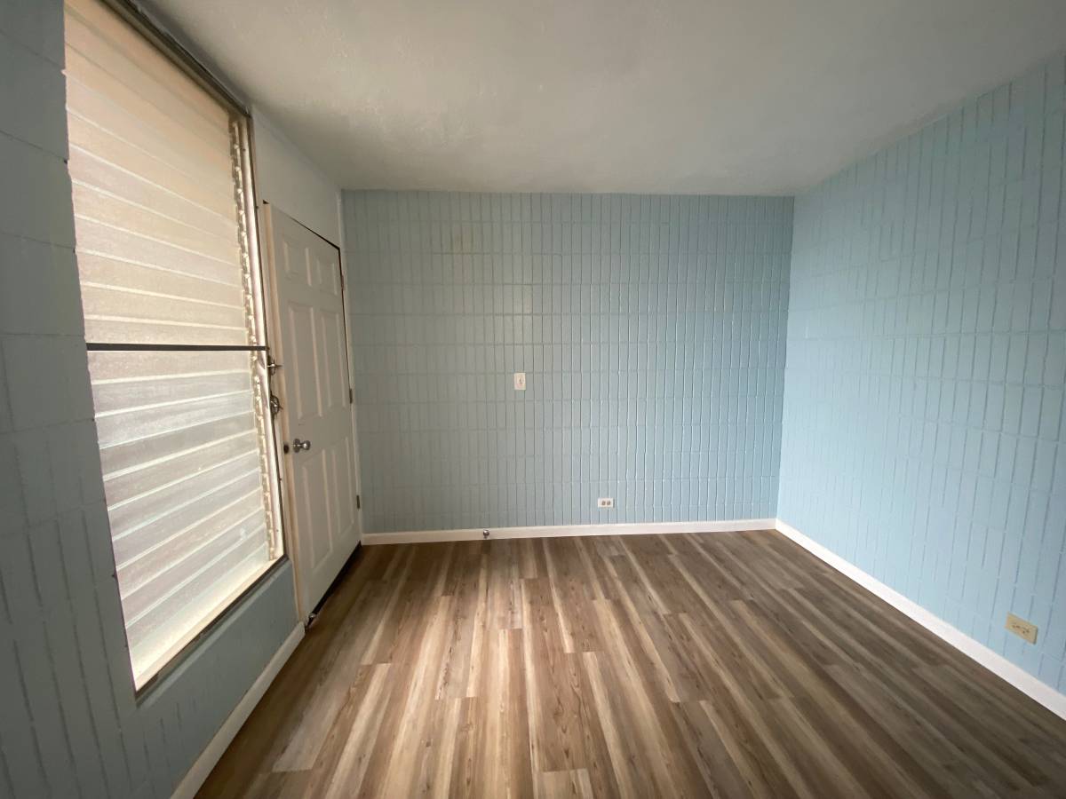 A room with wooden flooring and a closed door.